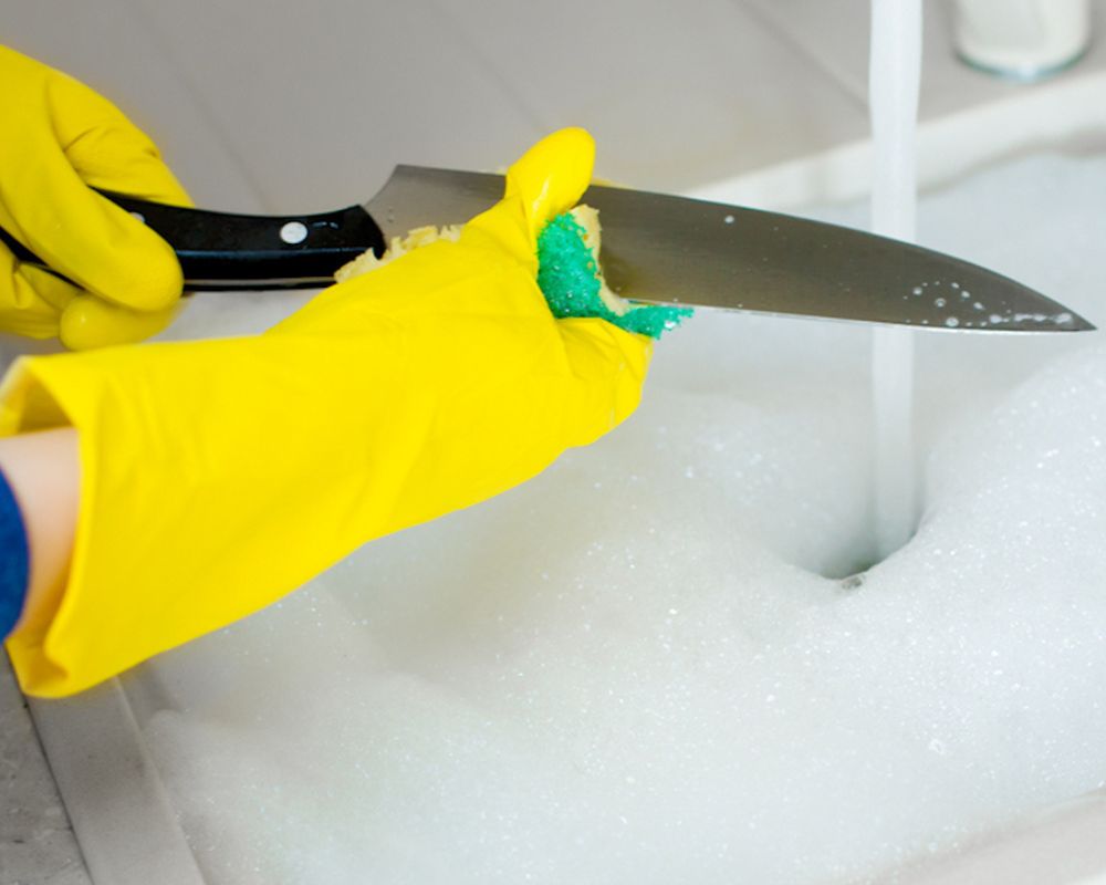 When must a knife be cleaned and sanitized?